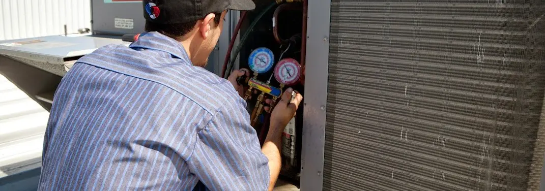 HVAC technician servicing a condenser unit in Acworth
